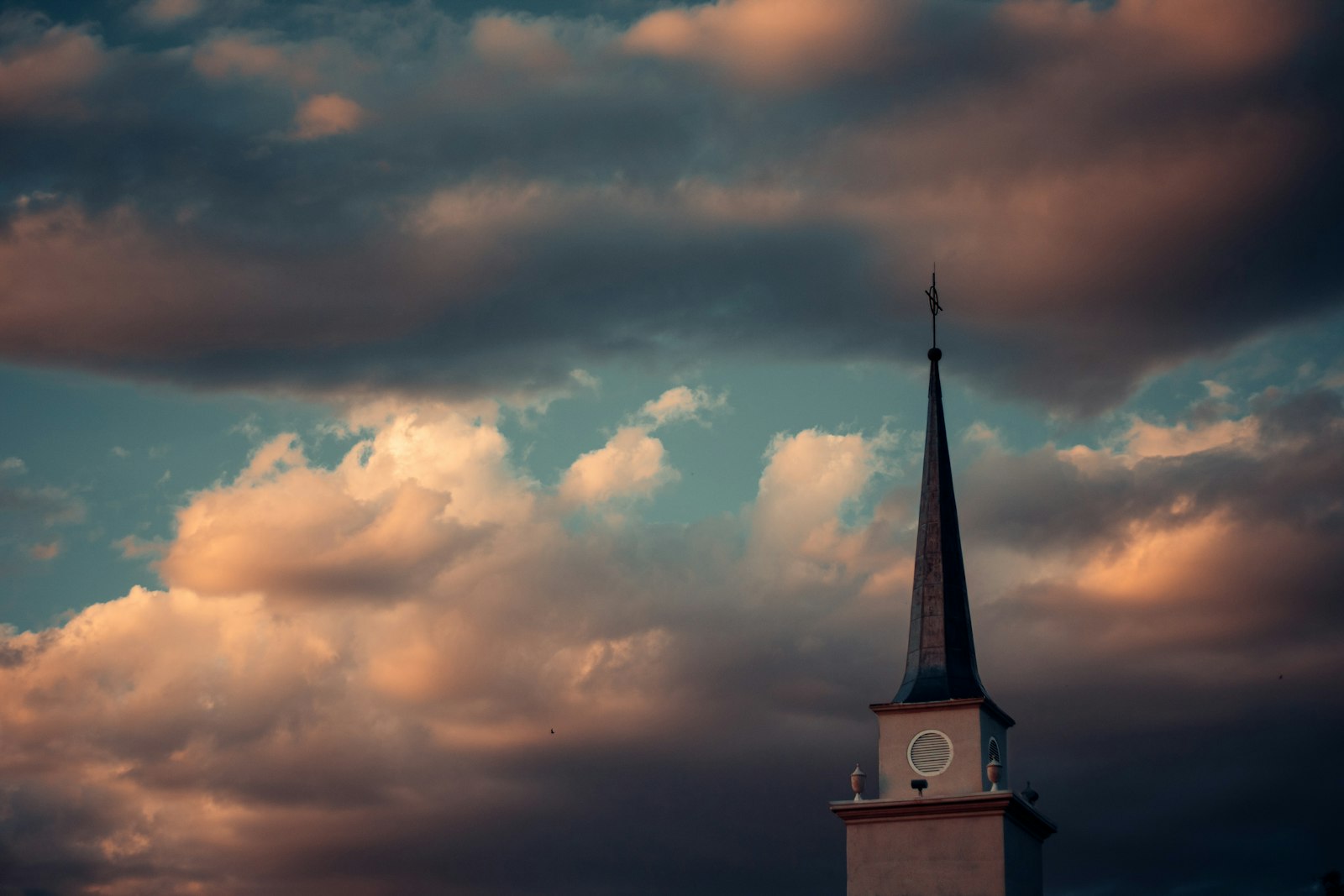 Church steeple against a golden sunset sky